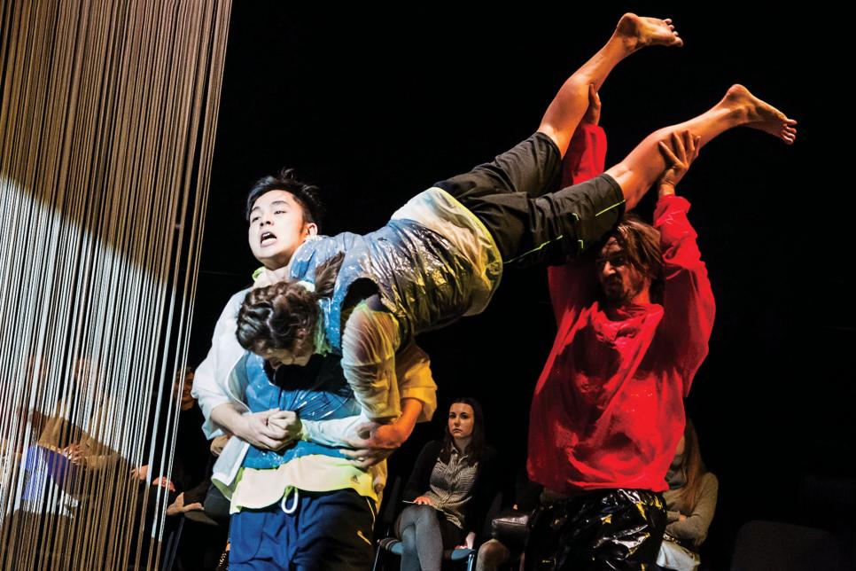 Two dancers holding another dancer in the air